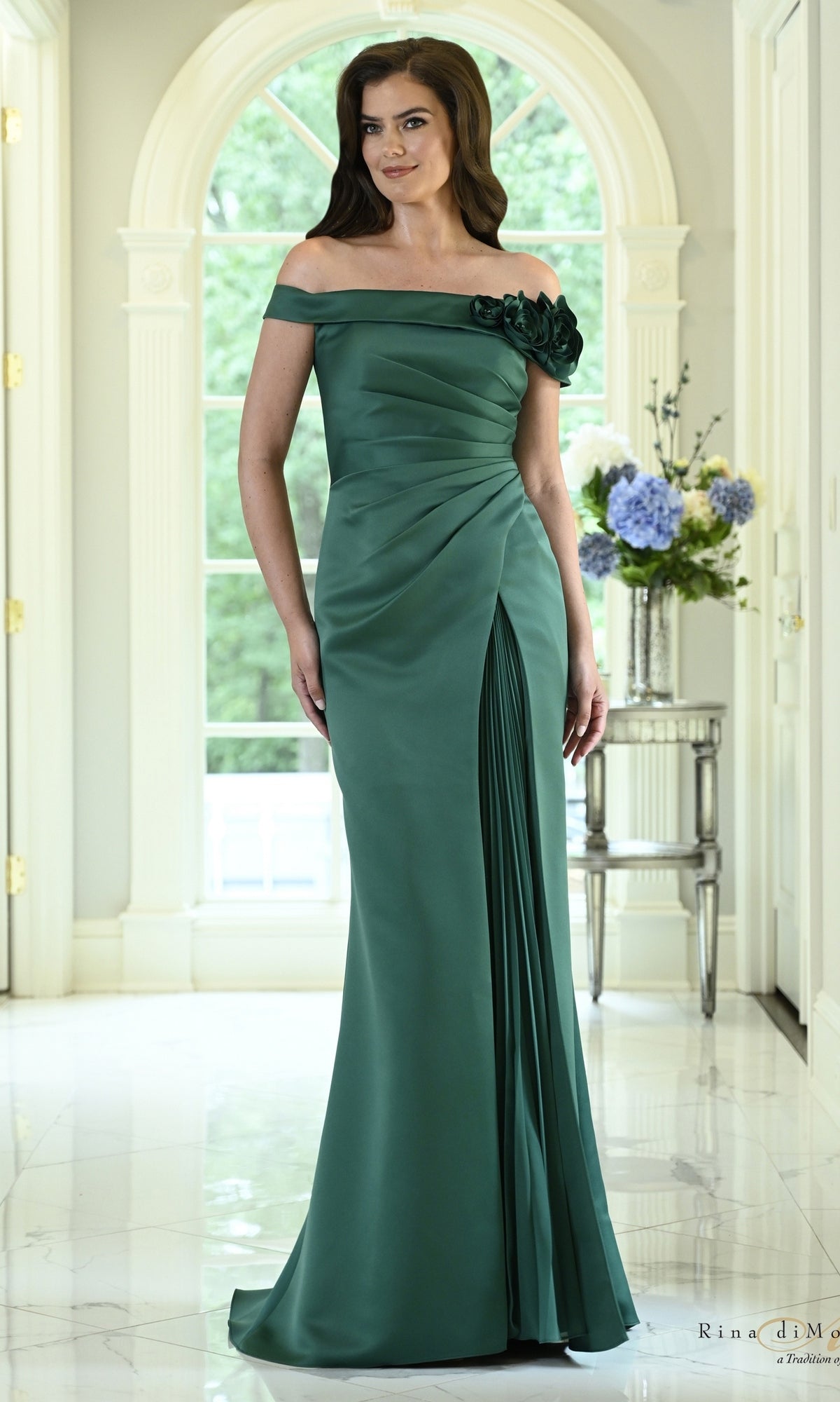 Deep green Off-the-Shoulder Rosette Satin Formal Dress: Rina Di Montella RD3639, an off-the-shoulder floor-length satin evening gown with a side rosette accent and a pleated skirt slit.